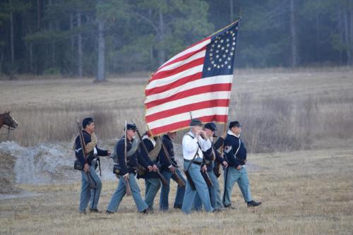 38th Brooksville Raid Civil War Re-enactment. Soldiers marching with the American Flag during battle.